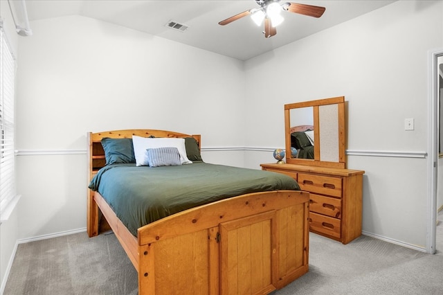 bedroom featuring light carpet, multiple windows, vaulted ceiling, and ceiling fan