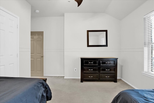 bedroom featuring light colored carpet and lofted ceiling