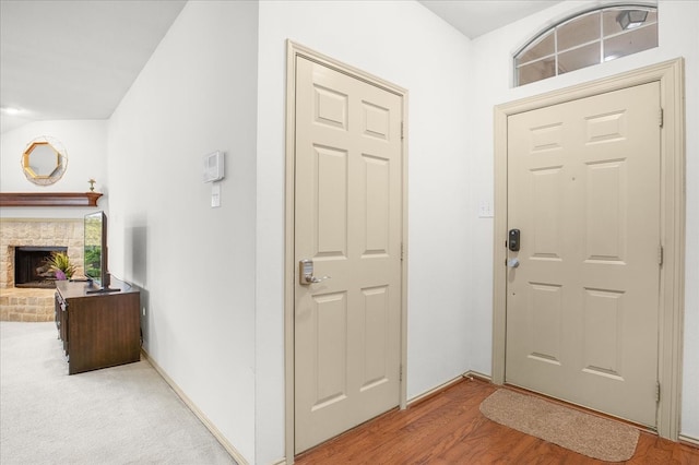 foyer featuring wood-type flooring and a fireplace