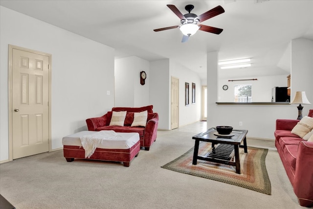 living room featuring lofted ceiling, light colored carpet, and ceiling fan