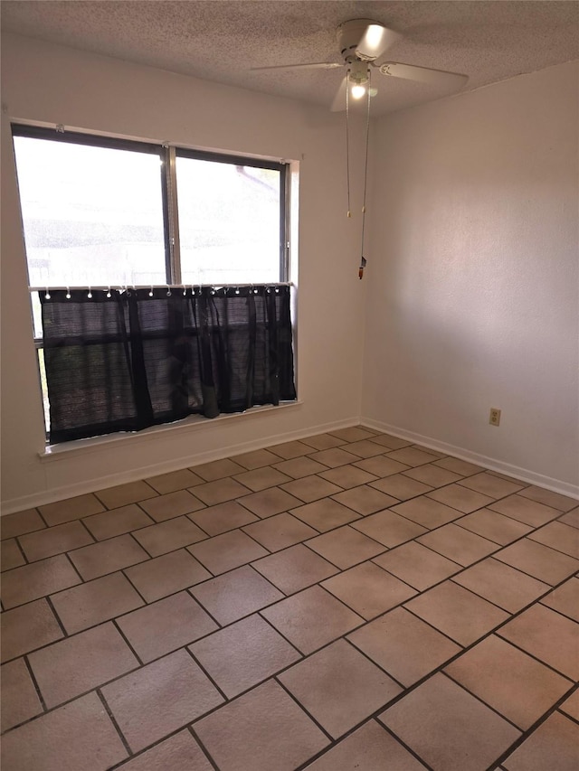 empty room with a textured ceiling and ceiling fan