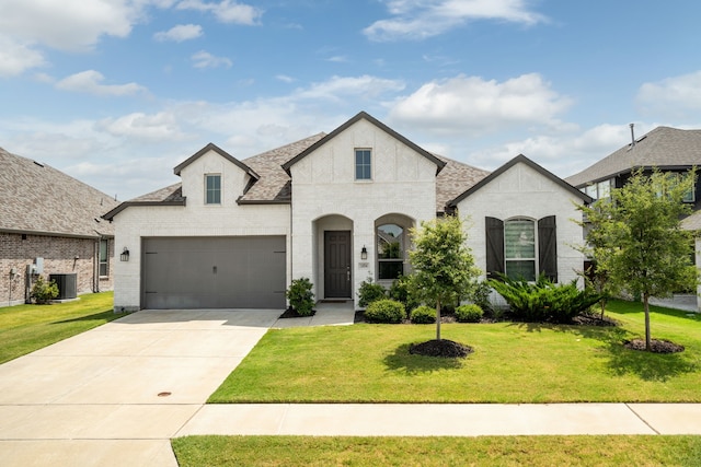 french provincial home with a front lawn, cooling unit, and a garage