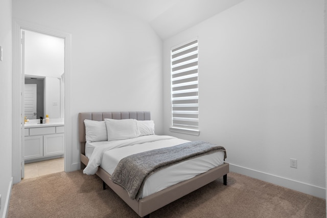 carpeted bedroom with lofted ceiling and connected bathroom