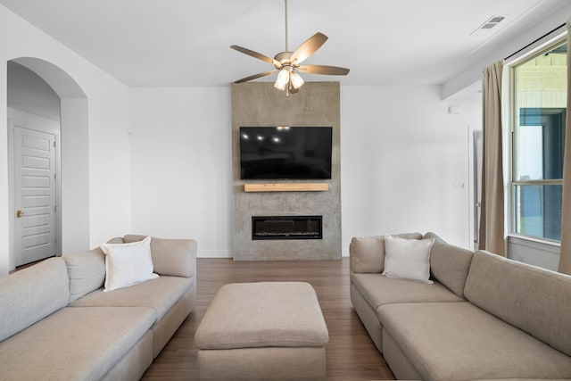 living room featuring ceiling fan, hardwood / wood-style floors, and a fireplace