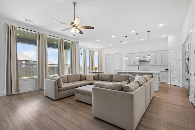 living room featuring ceiling fan and light hardwood / wood-style floors