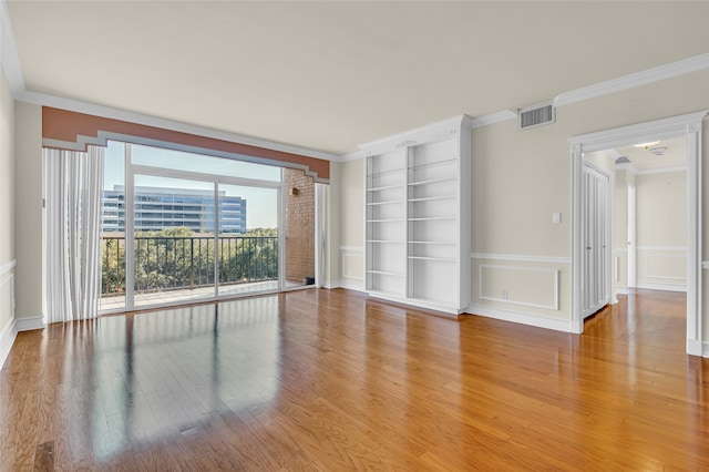 empty room with light wood-type flooring and crown molding