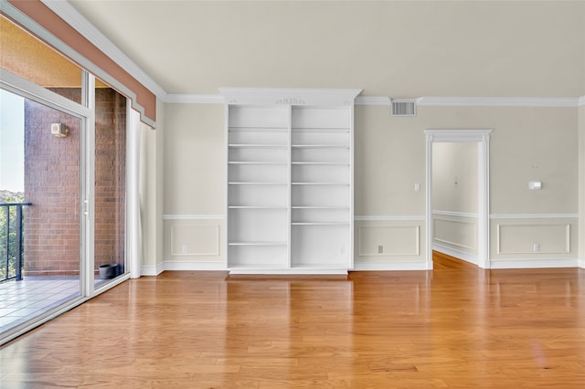 empty room with ornamental molding and light wood-type flooring