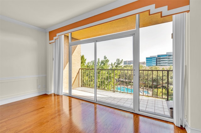 doorway to outside with ornamental molding and wood-type flooring