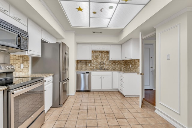 kitchen with sink, light tile patterned flooring, white cabinetry, and appliances with stainless steel finishes