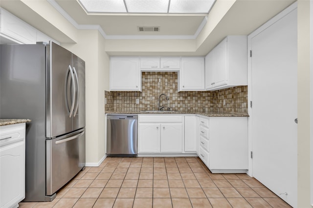 kitchen featuring sink, stainless steel appliances, dark stone countertops, and light tile patterned flooring