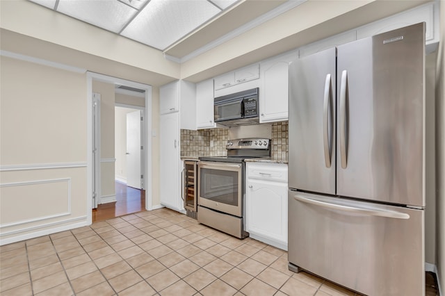 kitchen featuring white cabinets, light stone countertops, light tile patterned floors, and appliances with stainless steel finishes