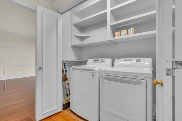 clothes washing area featuring light hardwood / wood-style flooring and washer and dryer