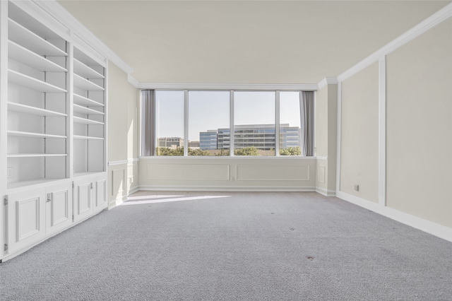 carpeted spare room featuring crown molding