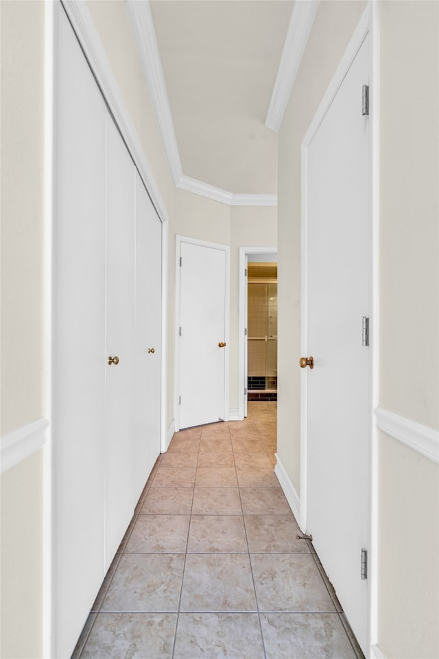 hall featuring crown molding and light tile patterned floors