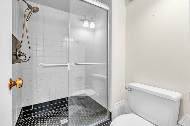 bathroom with toilet and an enclosed shower