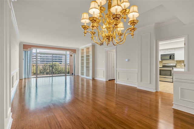 unfurnished dining area with crown molding, light hardwood / wood-style floors, and a notable chandelier