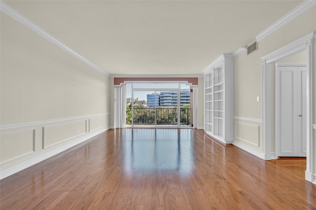 empty room featuring light hardwood / wood-style flooring and crown molding