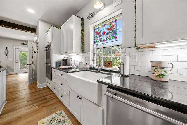 kitchen with white cabinetry, stainless steel appliances, tasteful backsplash, and plenty of natural light