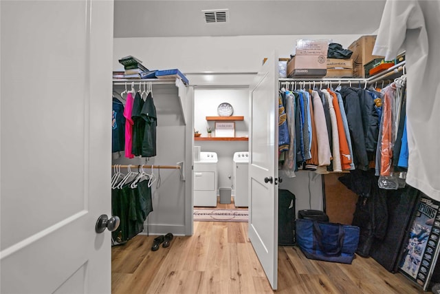 spacious closet with hardwood / wood-style flooring and washer and dryer