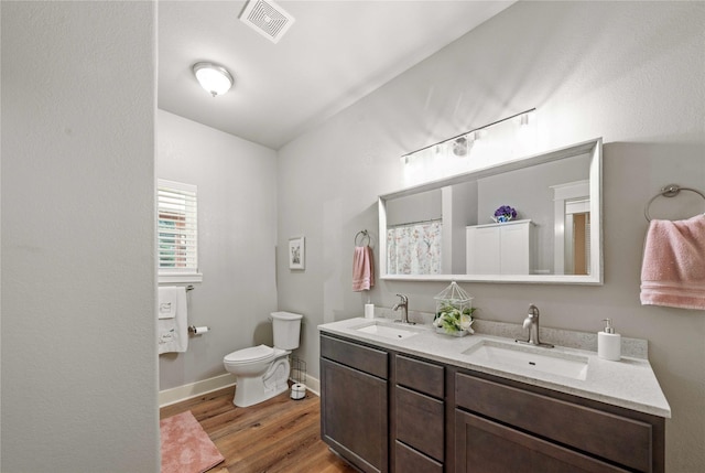 bathroom featuring vanity, toilet, and hardwood / wood-style floors