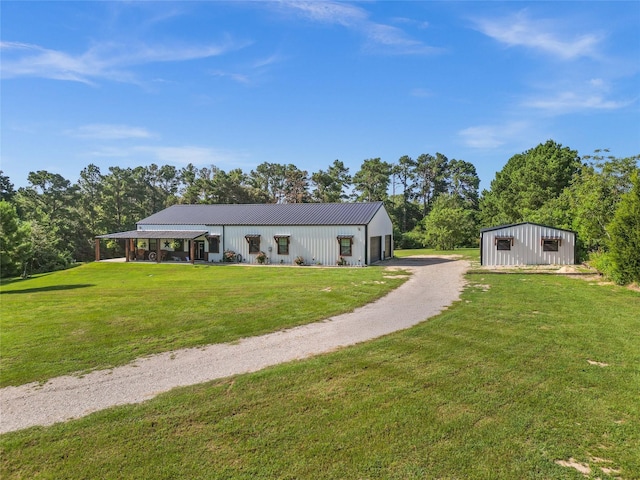 view of front of property with a garage, an outdoor structure, and a front yard