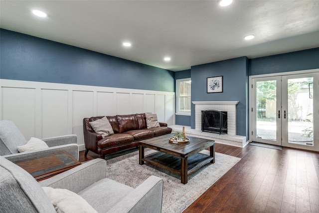 living room with wainscoting, dark wood-style flooring, a fireplace, and recessed lighting