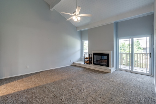 unfurnished living room with carpet flooring, a wealth of natural light, ceiling fan, and high vaulted ceiling