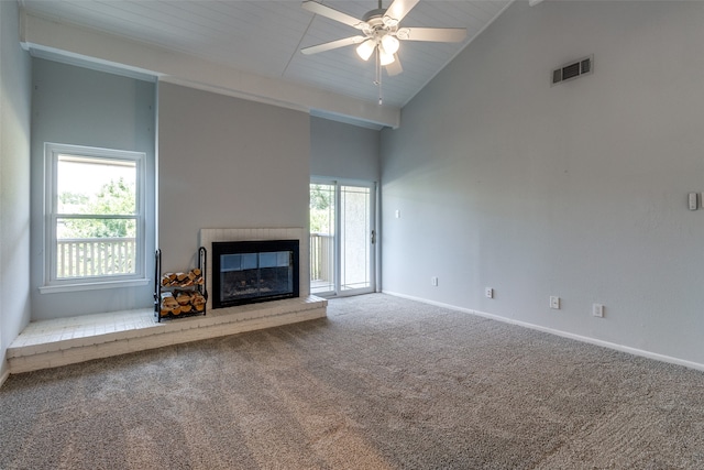 unfurnished living room with plenty of natural light, carpet floors, and high vaulted ceiling