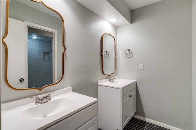 bathroom featuring a tile shower and vanity