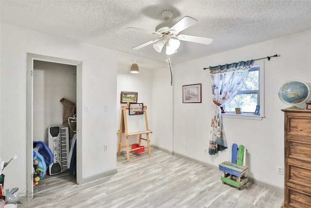 misc room with a textured ceiling, ceiling fan, and hardwood / wood-style floors