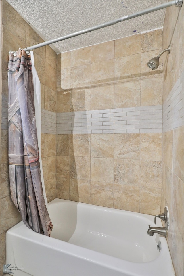 bathroom with shower / bathtub combination with curtain and a textured ceiling