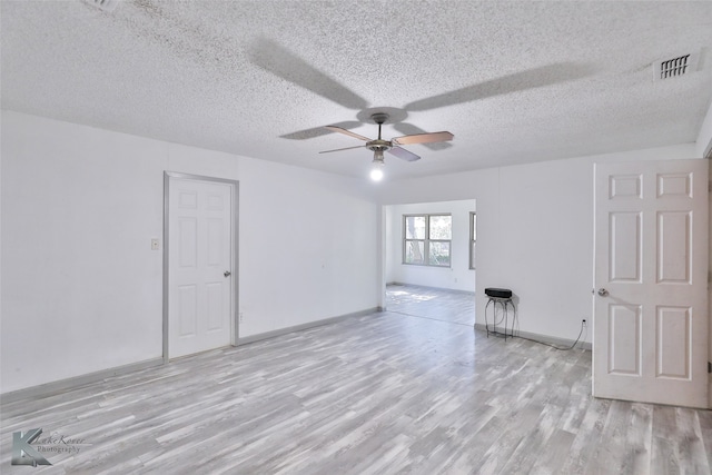 unfurnished room featuring light hardwood / wood-style floors, a textured ceiling, and ceiling fan