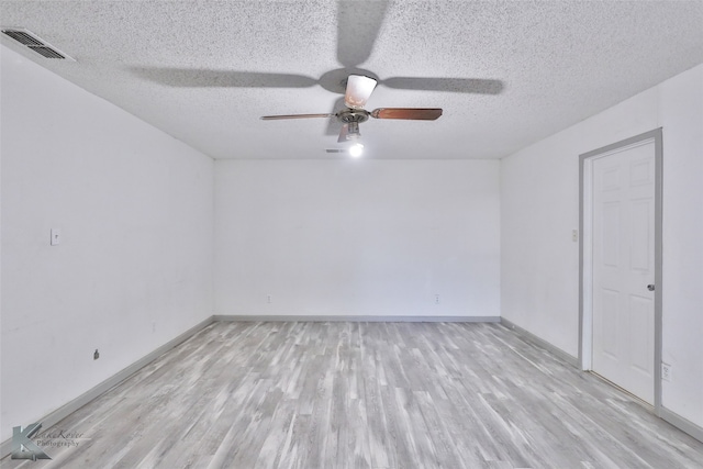 spare room with light hardwood / wood-style floors, a textured ceiling, and ceiling fan