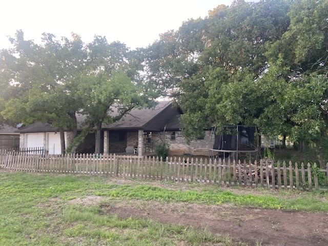 view of yard featuring a garage and a trampoline