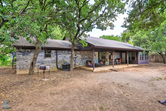 rear view of house featuring central AC unit and a patio area