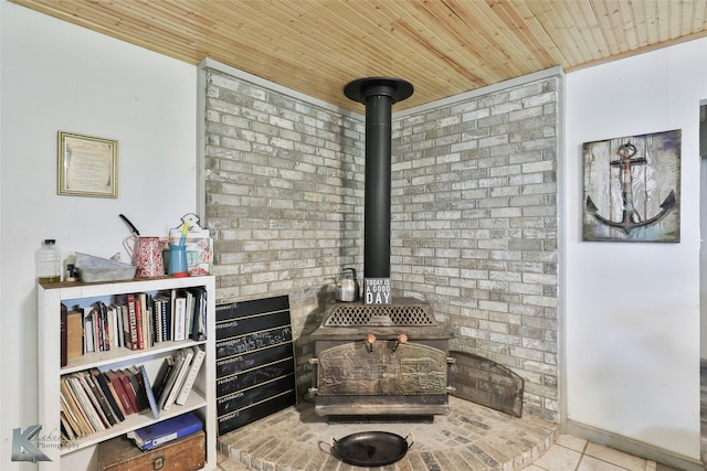 living area with light tile patterned flooring, a wood stove, wood ceiling, and brick wall