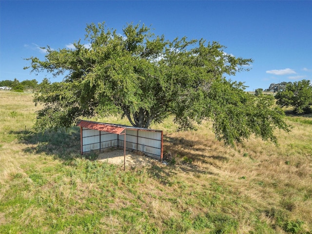 view of yard with an outdoor structure and a rural view