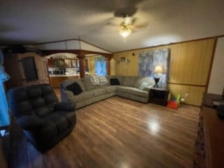 living room with hardwood / wood-style flooring, lofted ceiling, and ceiling fan