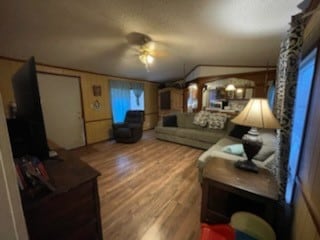 living room featuring wood-type flooring and ceiling fan