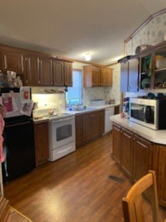 kitchen with light hardwood / wood-style floors, range hood, backsplash, and white appliances