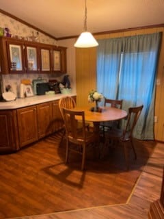 dining area with vaulted ceiling, crown molding, and hardwood / wood-style floors