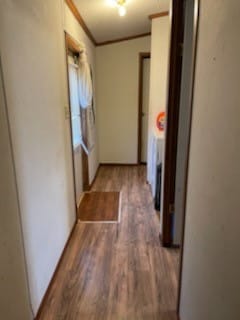 corridor featuring ornamental molding and hardwood / wood-style flooring