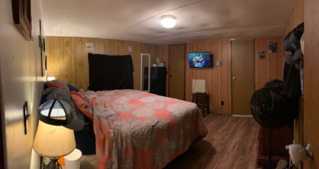 bedroom with wooden walls and wood-type flooring