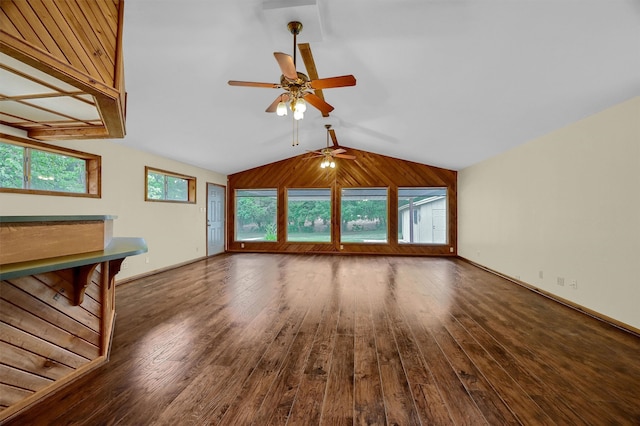 unfurnished living room with lofted ceiling, wood-type flooring, wood walls, and ceiling fan