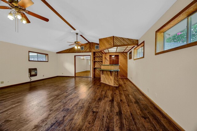 unfurnished living room with ceiling fan, wood walls, hardwood / wood-style flooring, and lofted ceiling