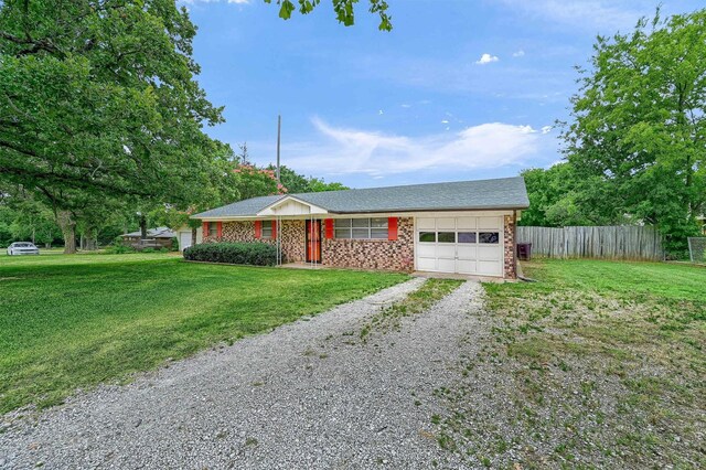 single story home featuring a garage and a front yard