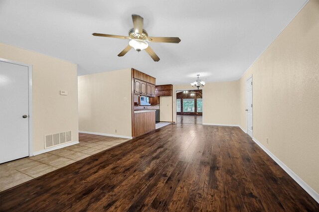 unfurnished living room with ceiling fan with notable chandelier and light wood-type flooring