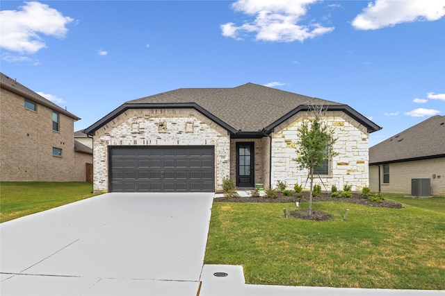 view of front of home featuring central air condition unit, a garage, and a front lawn