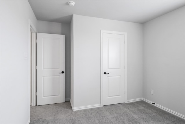 unfurnished bedroom with a closet and light carpet