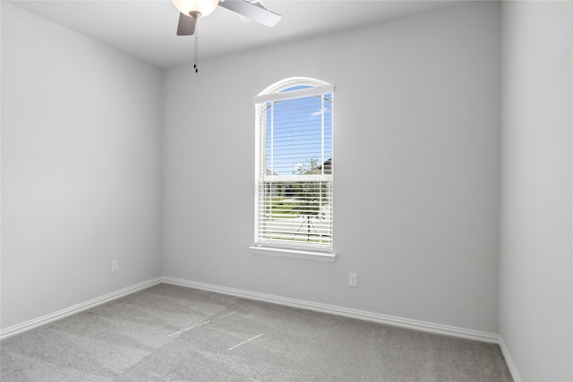 unfurnished room with a wealth of natural light, light colored carpet, and ceiling fan